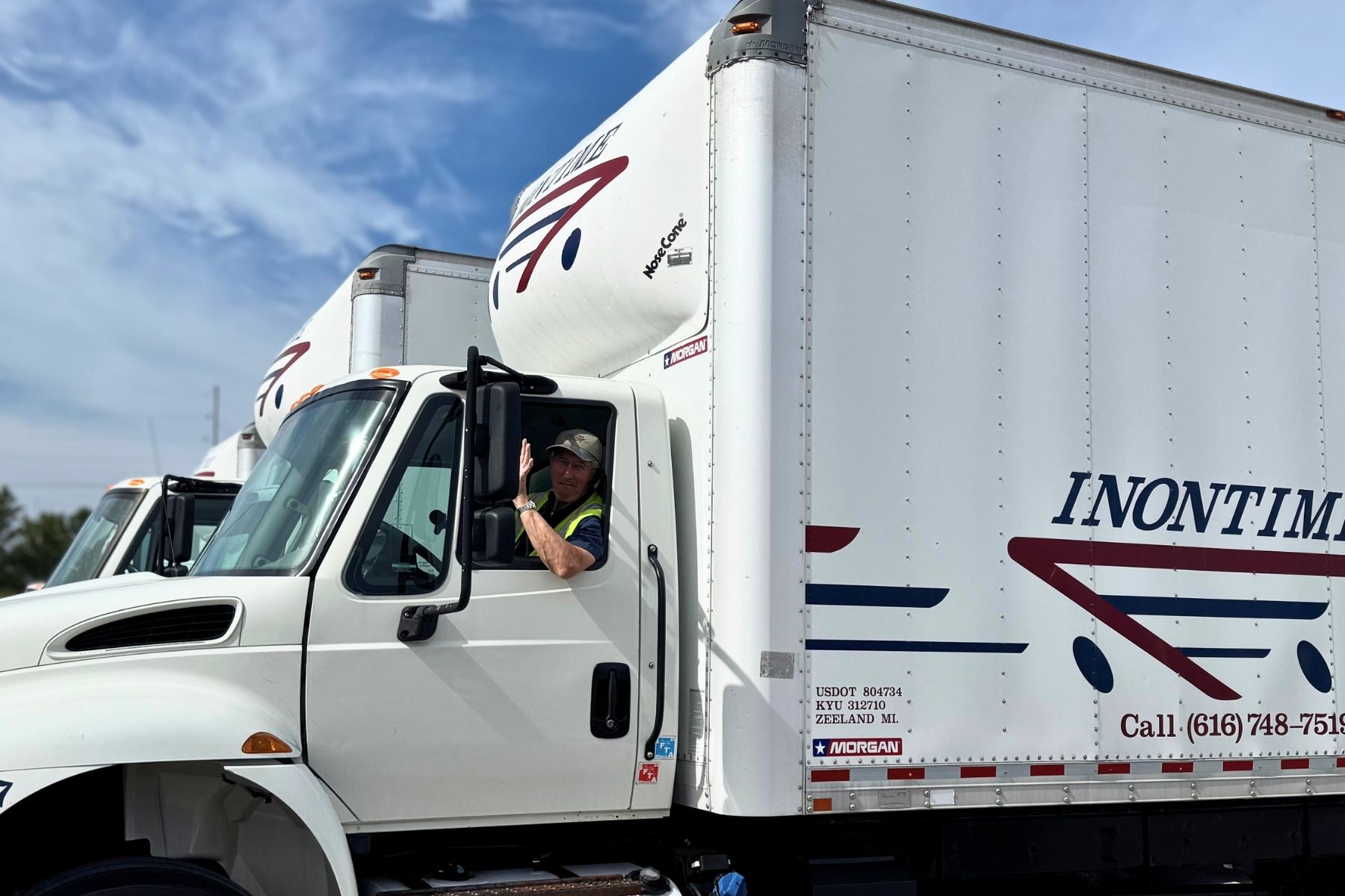 William Waving inontime box truck Inontime driver sitting in a box truck, smiling and waving, representing the personal relationships and service at the core of Inontime’s logistics.