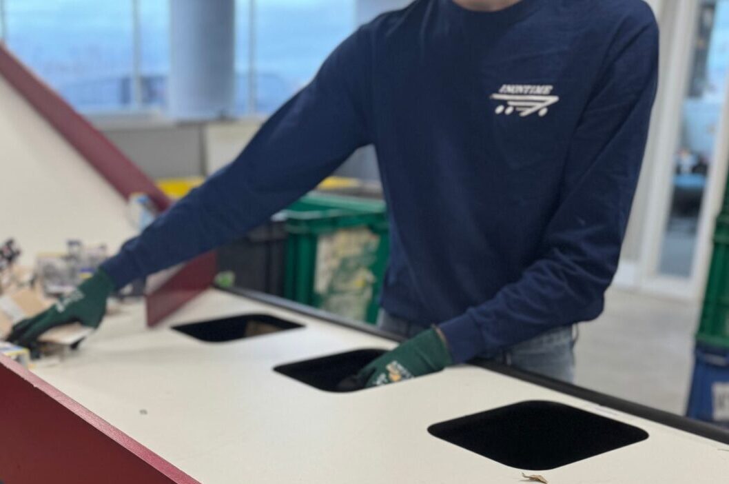 Sorting Warehouse team member sorting materials into designated bins at a workstation.